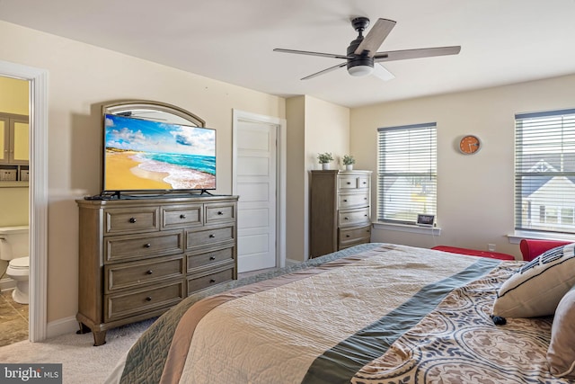 carpeted bedroom with ensuite bathroom and ceiling fan