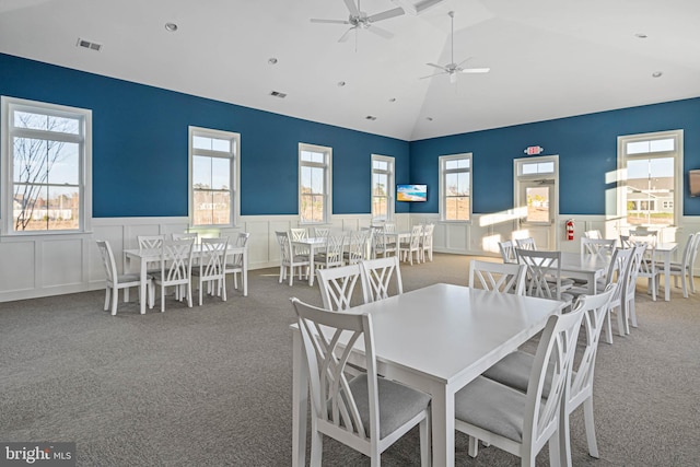 carpeted dining space featuring ceiling fan, lofted ceiling, and a wealth of natural light