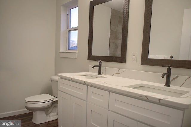 bathroom featuring wood-type flooring, vanity, and toilet