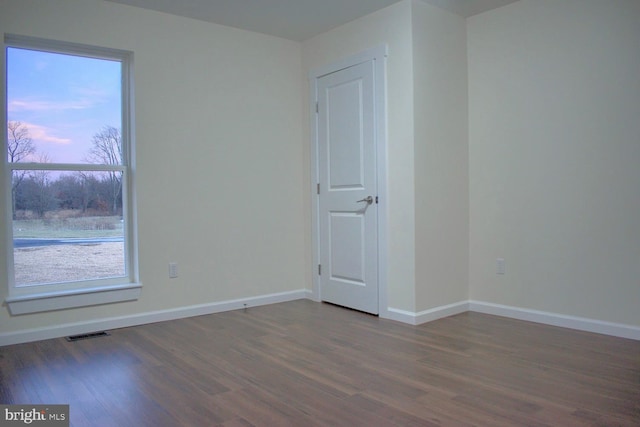 spare room with dark hardwood / wood-style floors