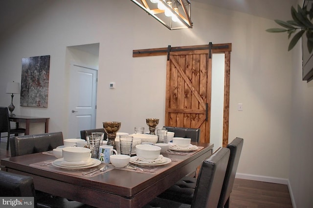 dining space with dark hardwood / wood-style floors and a barn door