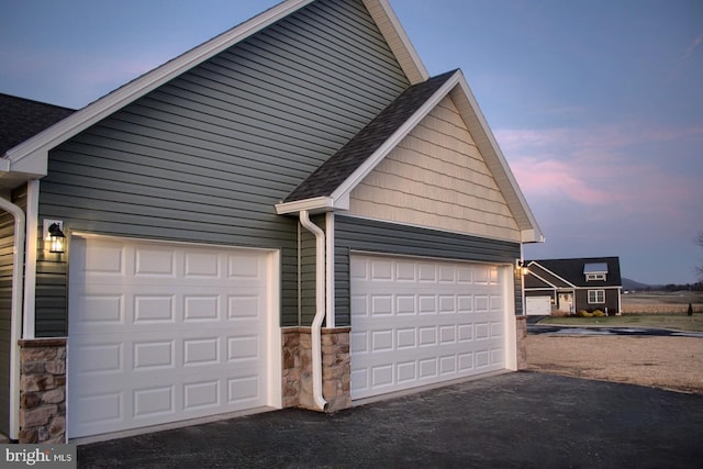 view of garage at dusk