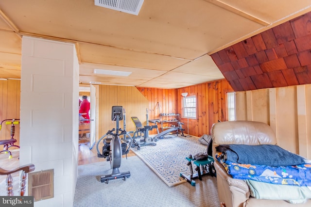 exercise area with carpet flooring and wooden walls