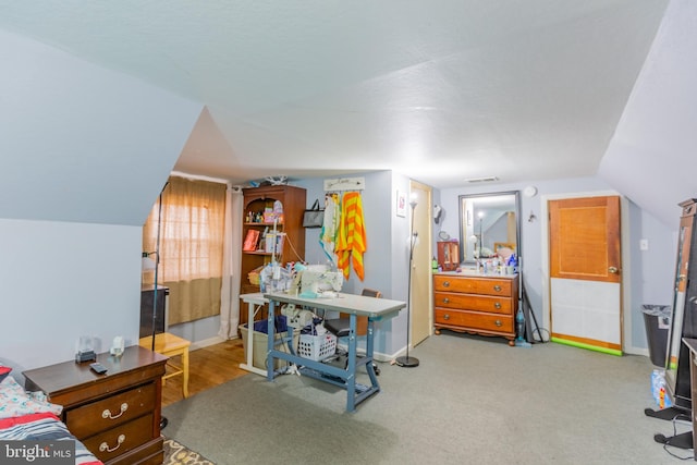 carpeted bedroom featuring a textured ceiling and vaulted ceiling