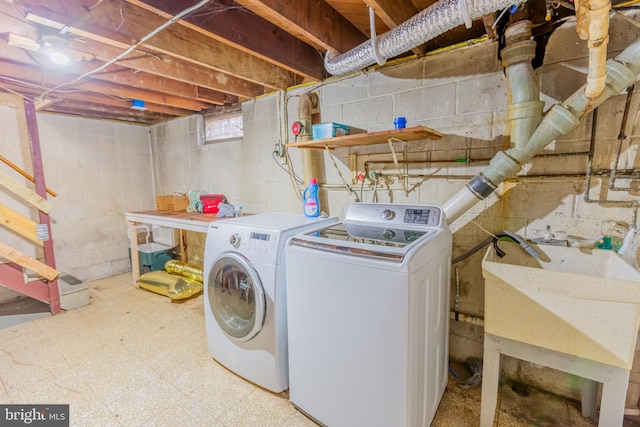 clothes washing area with washer and dryer and sink