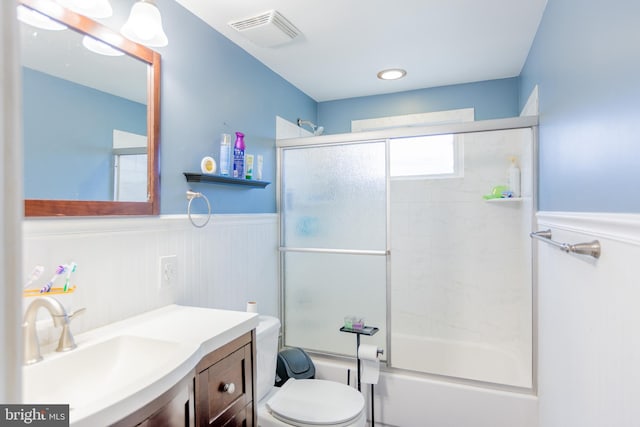 full bathroom featuring toilet, vanity, and combined bath / shower with glass door