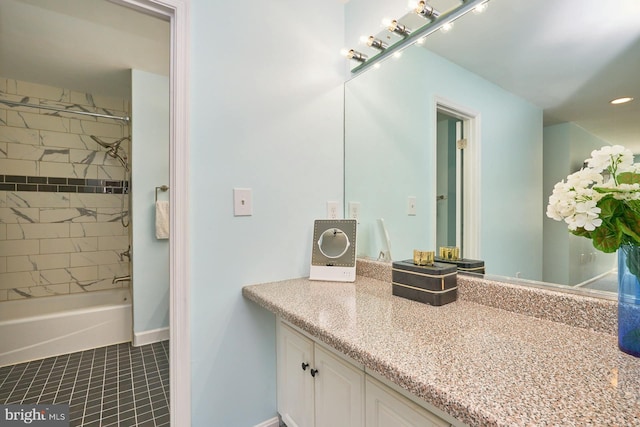 bathroom with tile patterned flooring, vanity, and tiled shower / bath combo