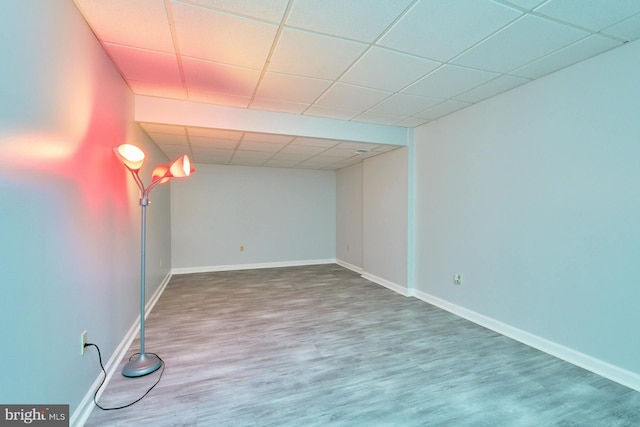 basement with a paneled ceiling and hardwood / wood-style floors