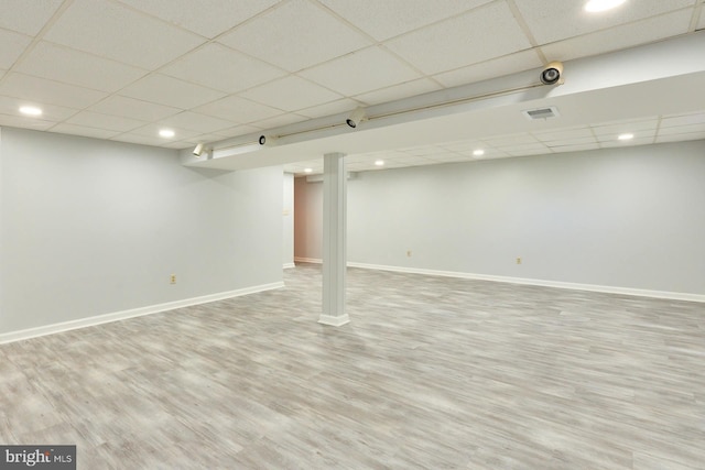 basement featuring hardwood / wood-style floors and a drop ceiling