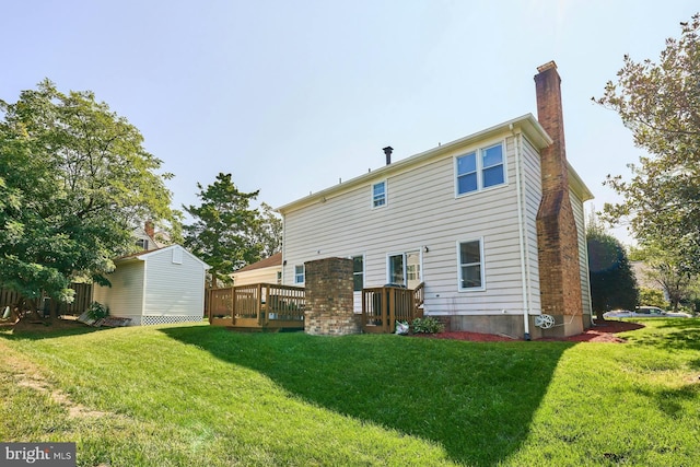 back of house featuring a lawn, a shed, and a deck