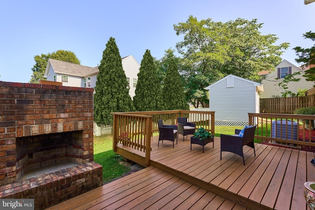 deck with an outdoor living space with a fireplace and a storage shed