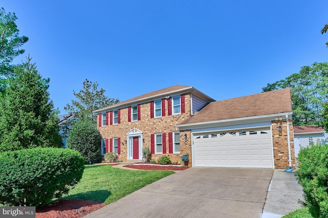 colonial inspired home with a garage and a front lawn