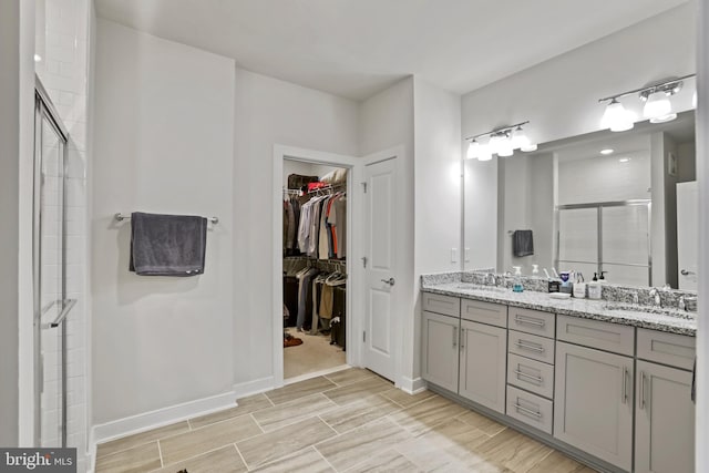 bathroom featuring vanity and a shower with door