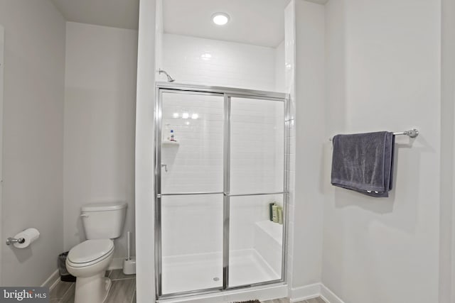 bathroom featuring toilet and an enclosed shower