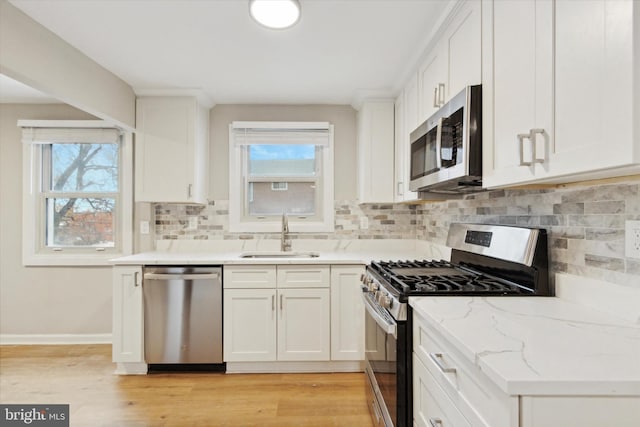 kitchen featuring a healthy amount of sunlight, sink, white cabinetry, and stainless steel appliances