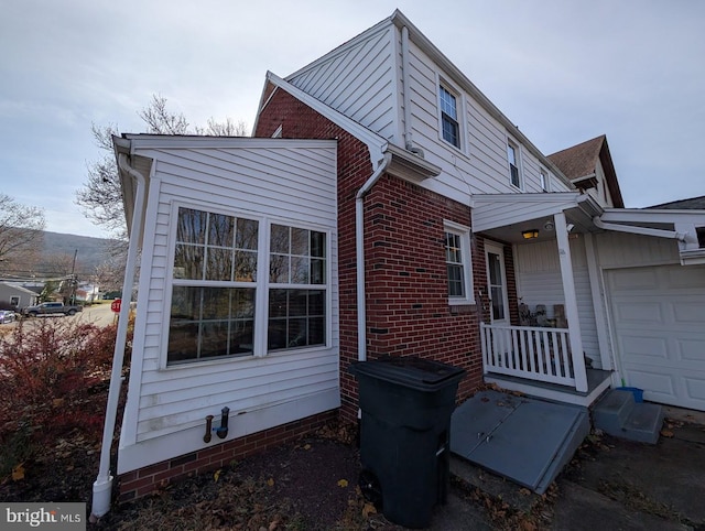 view of side of home with brick siding and an attached garage