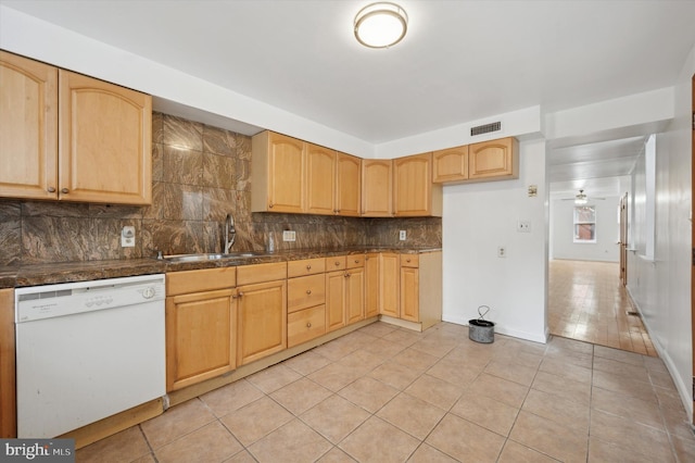 kitchen featuring dishwasher, light tile patterned floors, light brown cabinetry, decorative backsplash, and sink