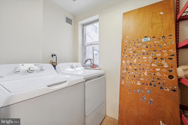 laundry area featuring light tile patterned floors and washer and clothes dryer