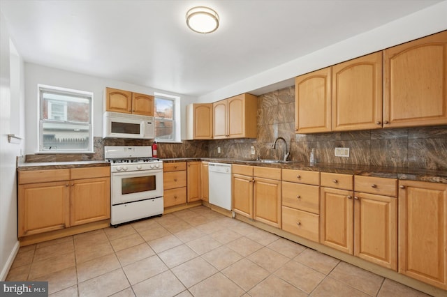 kitchen featuring sink, white appliances, light tile patterned floors, light brown cabinetry, and backsplash