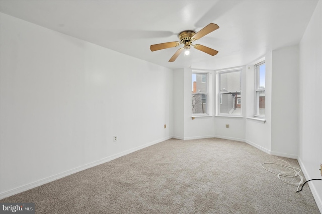 spare room featuring light colored carpet and ceiling fan