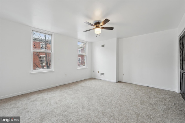 spare room featuring ceiling fan and light colored carpet