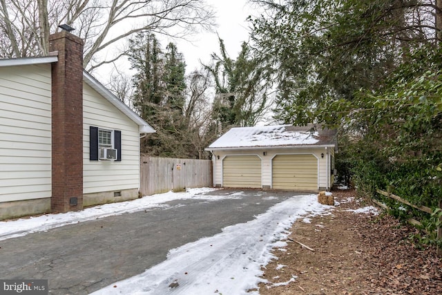 snow covered garage with cooling unit