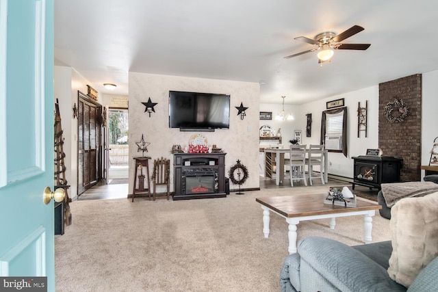 living room with ceiling fan with notable chandelier and a wood stove