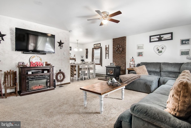 living room featuring ceiling fan, cooling unit, carpet, and a wood stove