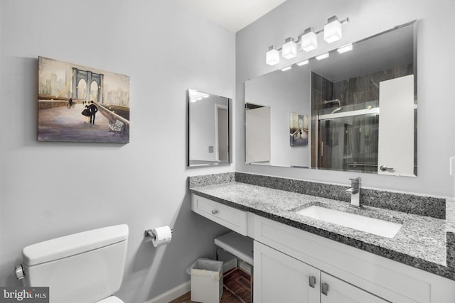 bathroom featuring vanity, toilet, and a shower with door