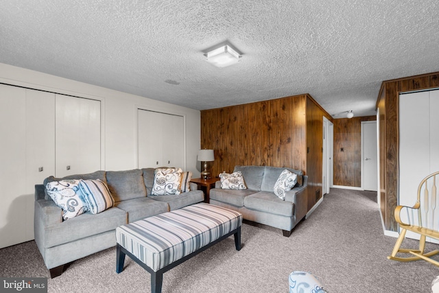 carpeted living room featuring a textured ceiling and wooden walls