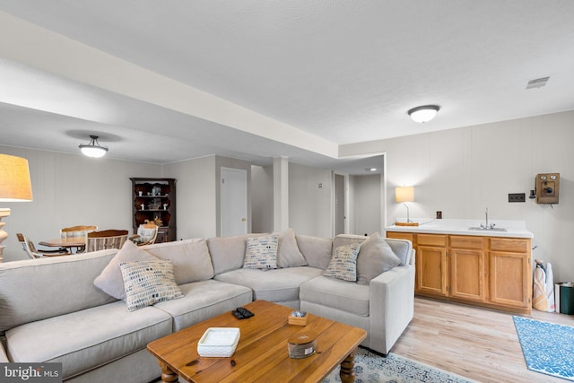 living room featuring light hardwood / wood-style floors and sink