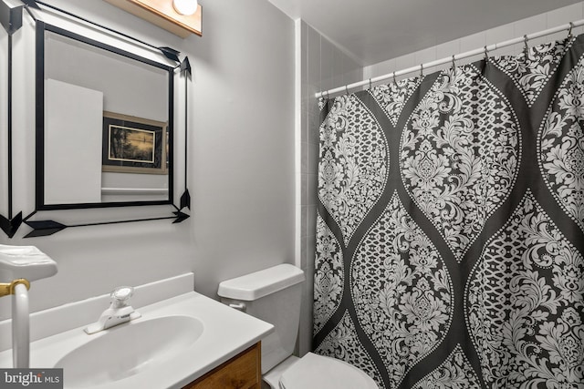 bathroom with a shower with shower curtain, vanity, and toilet