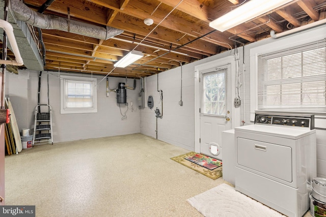 basement with electric panel, a healthy amount of sunlight, and washer / dryer