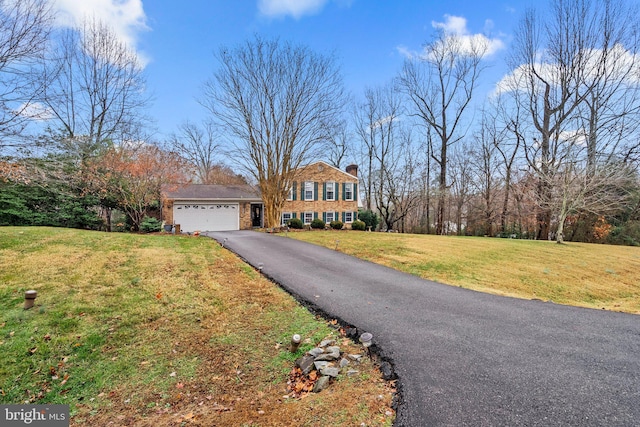 view of front facade with a garage and a front lawn