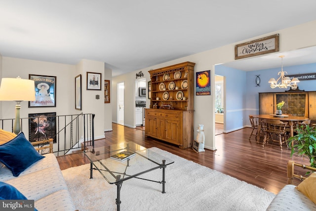 living room with a notable chandelier and dark hardwood / wood-style flooring