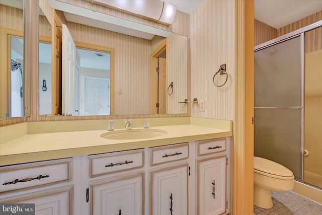 bathroom with walk in shower, vanity, and toilet