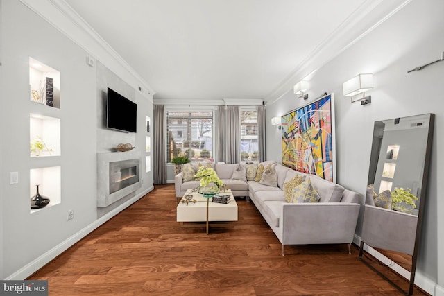 living room featuring dark hardwood / wood-style floors, a large fireplace, and ornamental molding