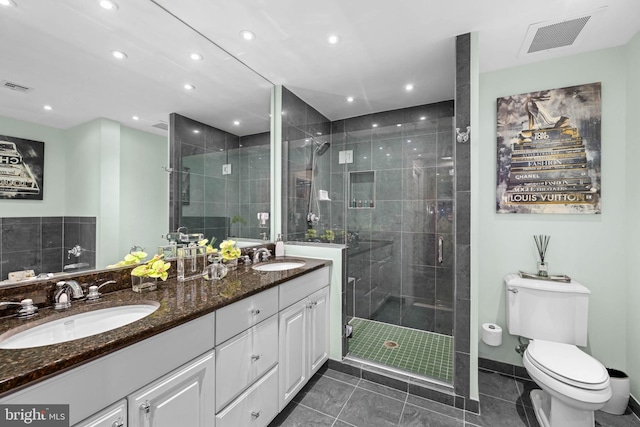 bathroom featuring tile patterned flooring, vanity, toilet, and a shower with shower door