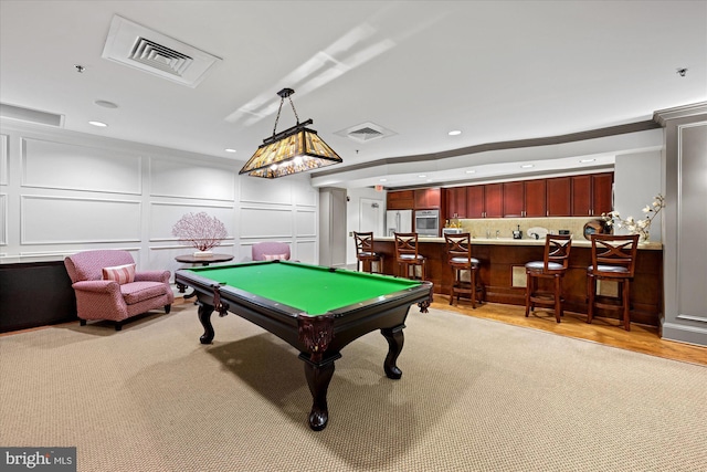 recreation room featuring bar area, light wood-type flooring, and pool table