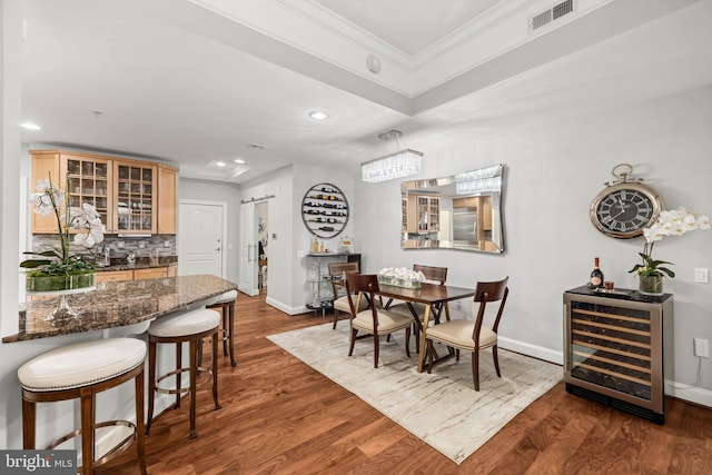 dining space featuring dark hardwood / wood-style floors, wine cooler, and crown molding