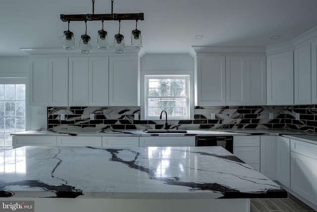 kitchen with white cabinetry, light stone countertops, hardwood / wood-style floors, decorative backsplash, and a kitchen island