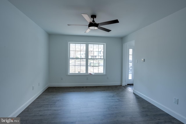 empty room with ceiling fan and dark hardwood / wood-style flooring