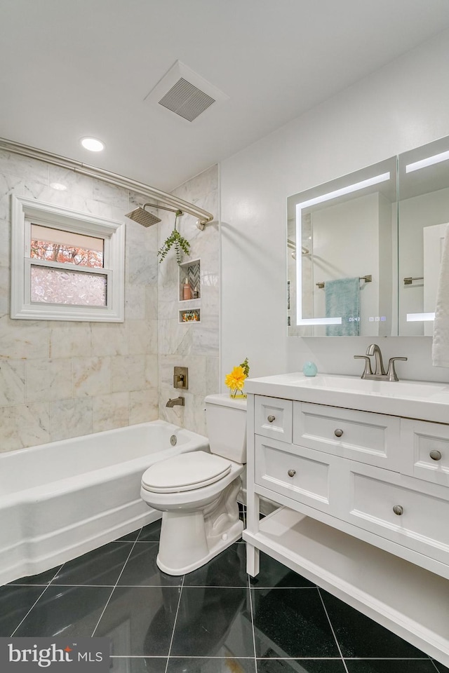 full bathroom with vanity, tiled shower / bath combo, tile patterned floors, and toilet