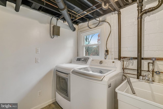 laundry area featuring washer and clothes dryer, hardwood / wood-style floors, and sink