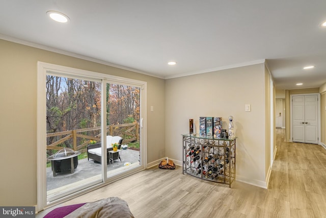 living area featuring light hardwood / wood-style floors and crown molding