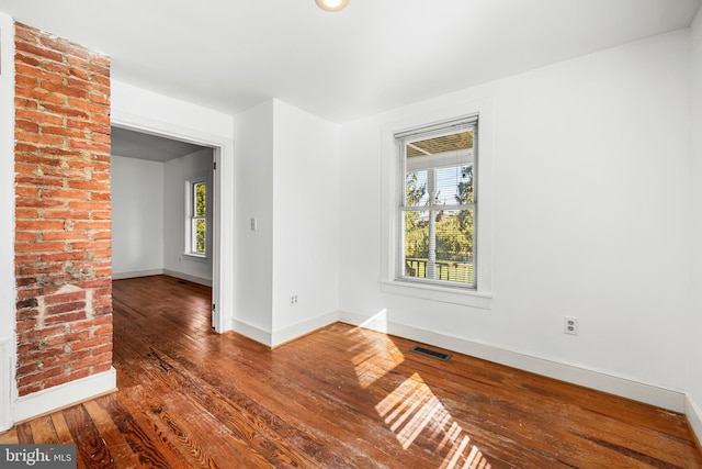 unfurnished room with dark hardwood / wood-style floors and a healthy amount of sunlight