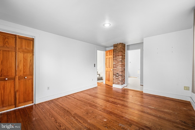 unfurnished bedroom with hardwood / wood-style flooring and a closet