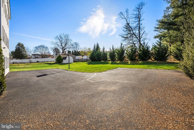 exterior space featuring a lawn and basketball court