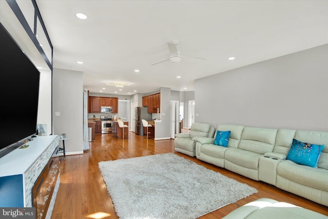 living room with ceiling fan and light hardwood / wood-style floors