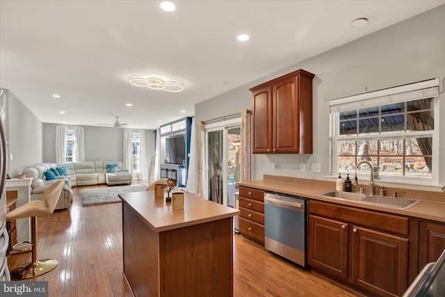 kitchen with a wealth of natural light, dishwasher, a kitchen island, and sink